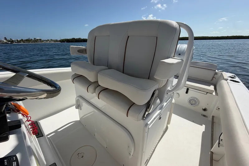Slide: The Image of 2022 Sea Hunt Ultra 239SE boat interior with dual captain's chairs on a sunny day. - 33