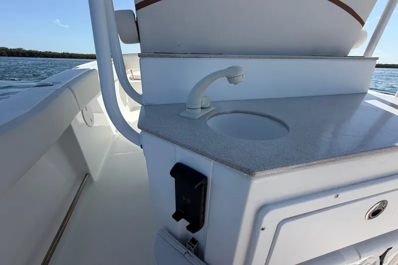 Slide: The Image of 2022 Sea Hunt Ultra 239SE boat interior with sink and storage compartment. - 48