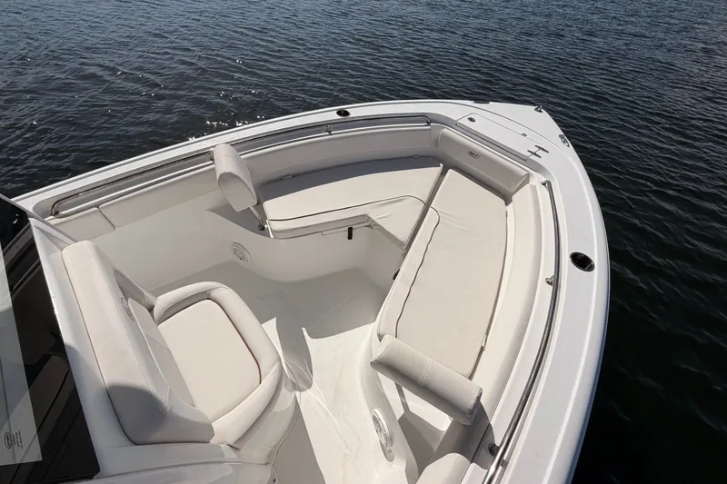 Slide: The Image of 2022 Sea Hunt Ultra 239SE boat with spacious seating on calm water. - 10