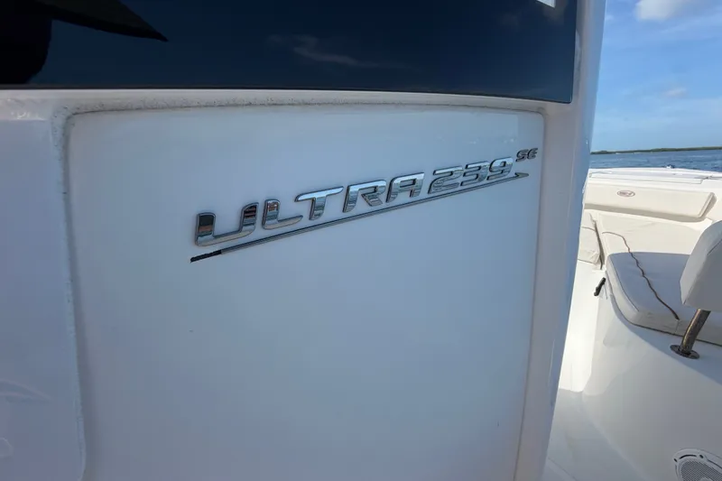 Slide: The Image of 2022 Sea Hunt Ultra 239SE boat emblem on white surface, sunny day. - 28