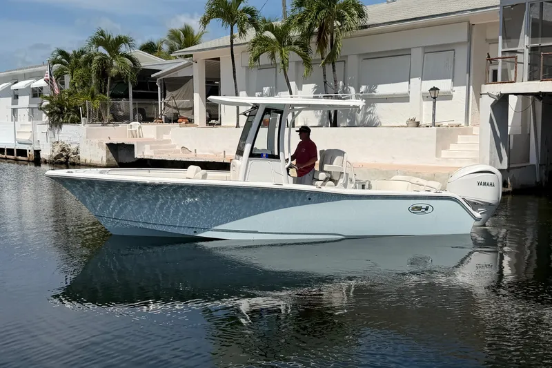 The Image of 2022 Sea Hunt Ultra 239SE boat docked near waterfront home with palm trees. - 0