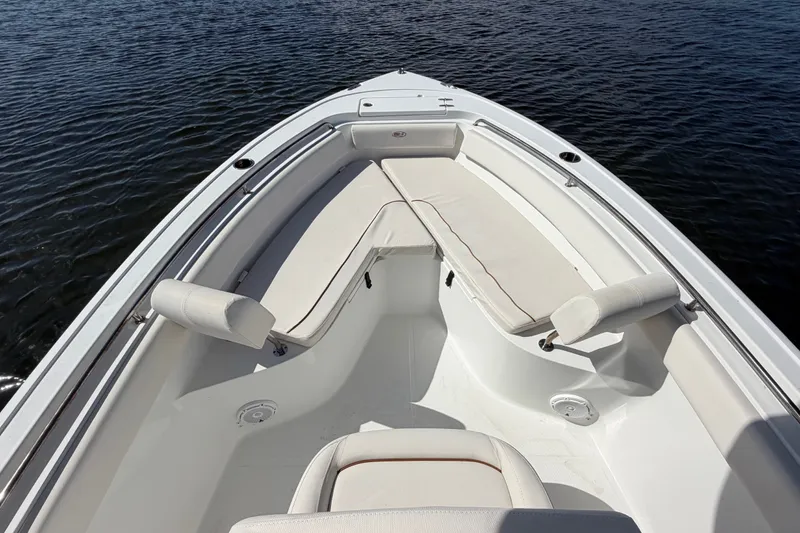 Slide: The Image of 2022 Sea Hunt Ultra 239SE boat interior with cushioned seating on calm water. - 8