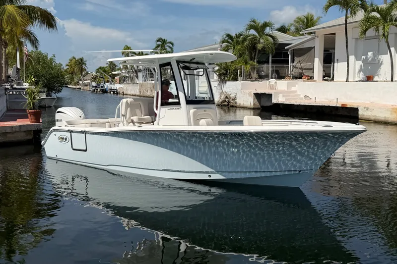 Slide: The Image of 2022 Sea Hunt Ultra 239SE boat docked in a sunny marina setting. - 4