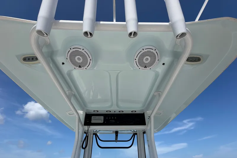 Slide: The Image of 2022 Sea Hunt Ultra 239SE boat T-top with speakers against blue sky. - 17