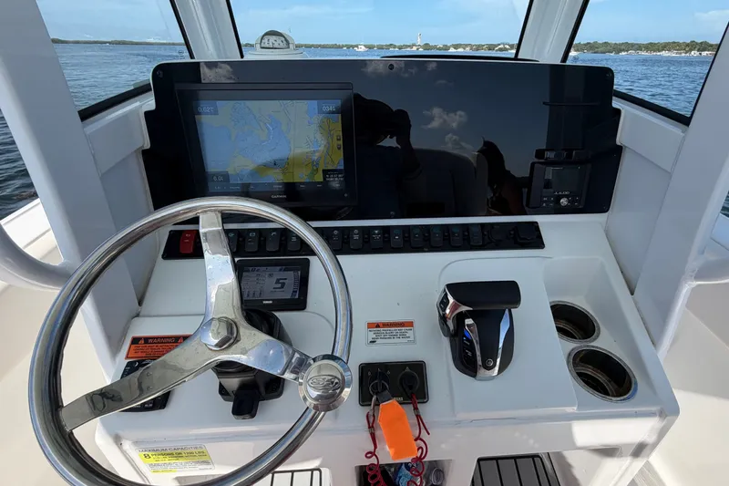 Slide: The Image of Cockpit of 2022 Sea Hunt Ultra 239SE boat with steering wheel and navigation display. - 20