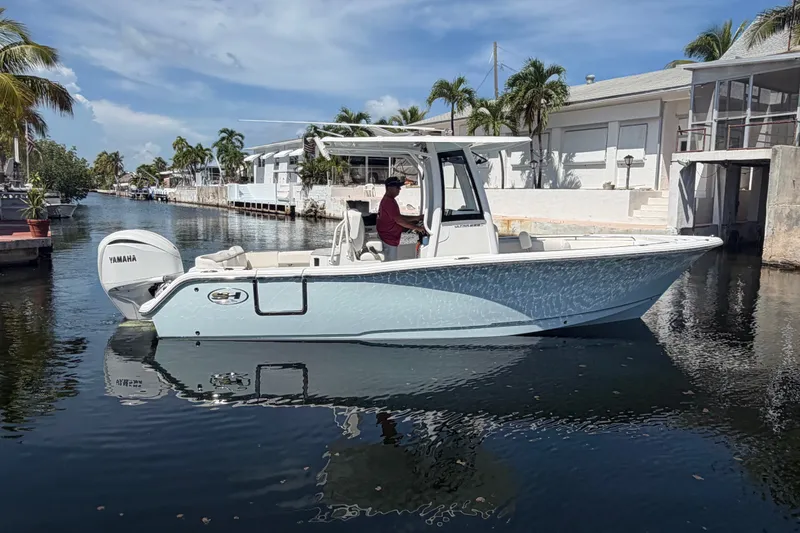 Slide: The Image of 2022 Sea Hunt Ultra 239SE boat on a sunny canal, featuring a Yamaha engine. - 3