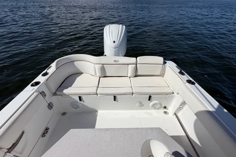 Slide: The Image of 2022 Sea Hunt Ultra 239SE boat with cushioned seating on calm water. - 35