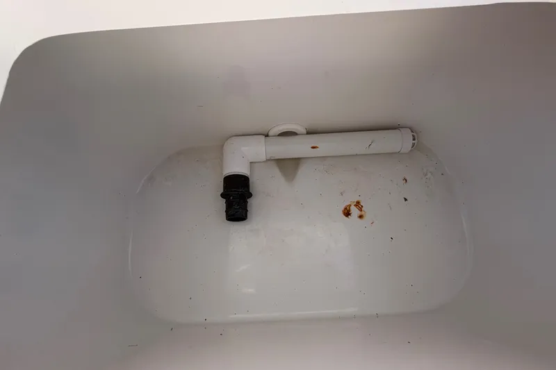 Slide: The Image of White compartment with pipe inside a 2022 Sea Hunt Ultra 239SE boat. - 56