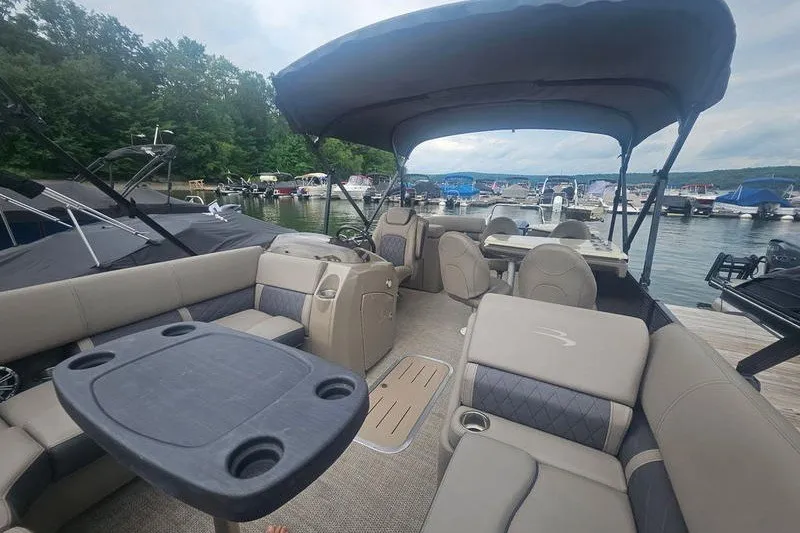 Slide: The Image of 2019 Bennington SX 23 SPDXP pontoon boat with spacious seating and canopy at a marina. - 14