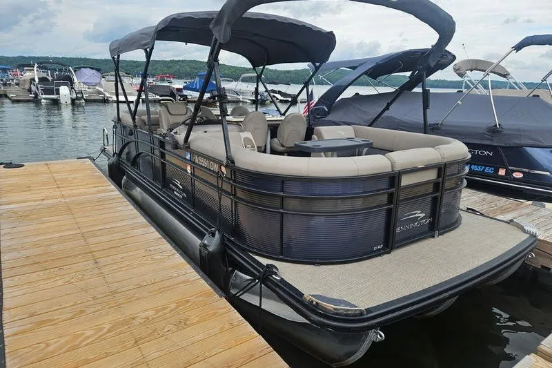 Slide: The Image of 2019 Bennington SX 23 SPDXP pontoon boat docked at a marina. - 1