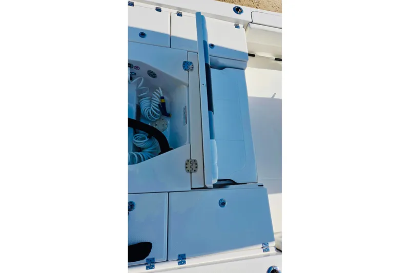 Slide: The Image of 2023 Robalo 266 Cayman boat storage compartment with coiled hose and seating. - 13