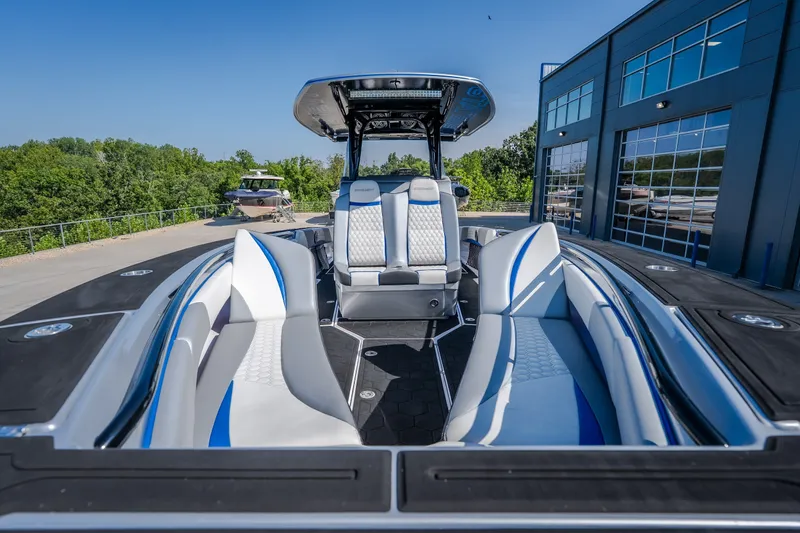 Slide: The Image of 2022 Statement 350 Open boat with sleek seating, docked near a modern building. - 44
