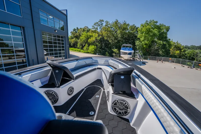 Slide: The Image of 2022 Statement 350 Open boat interior with modern seating and speakers, docked near a building. - 36