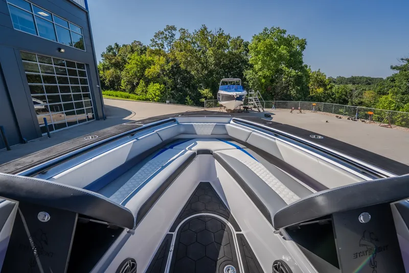 Slide: The Image of 2022 Statement 350 Open boat interior with sleek seating, docked near a modern building. - 37