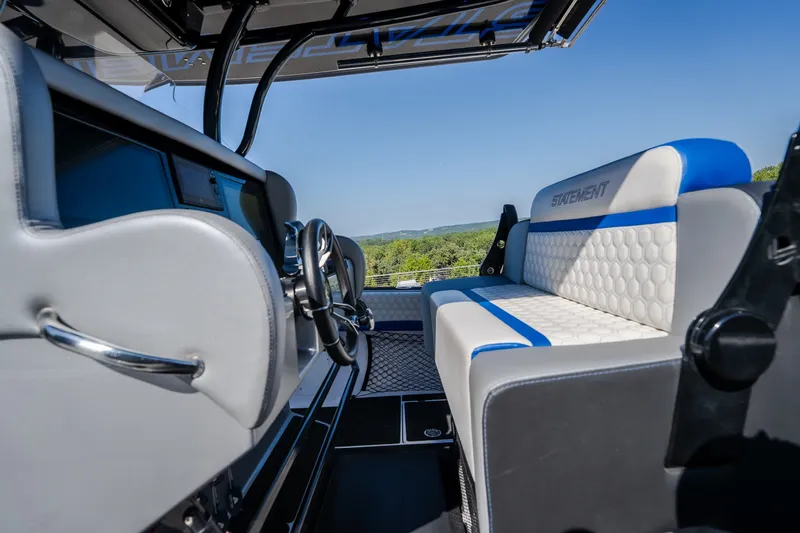 Slide: The Image of 2022 Statement 350 Open boat interior with modern seating and steering wheel, overlooking scenic landscape. - 41