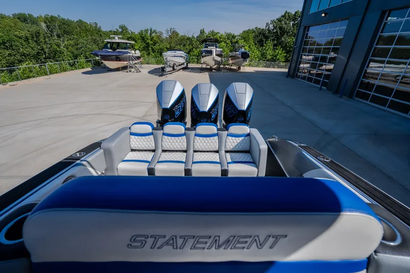 Slide: The Image of 2022 Statement 350 Open boat with triple engines, parked near other boats and a modern building. - 60