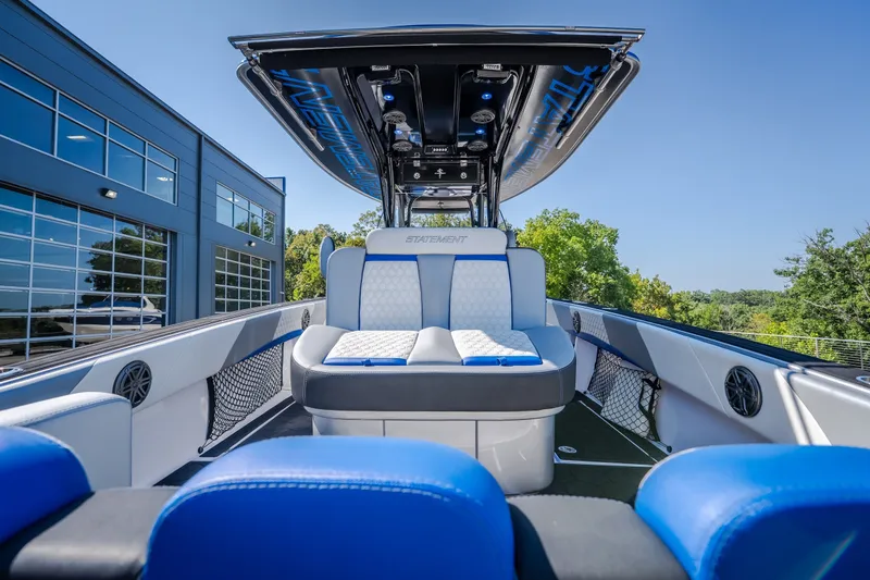 Slide: The Image of 2022 Statement 350 Open boat interior with blue and white seating, docked near modern building. - 18