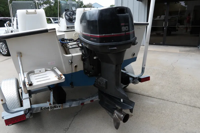 Slide: The Image of 1991 Boston Whaler SL16 boat with outboard motor on a trailer. - 14