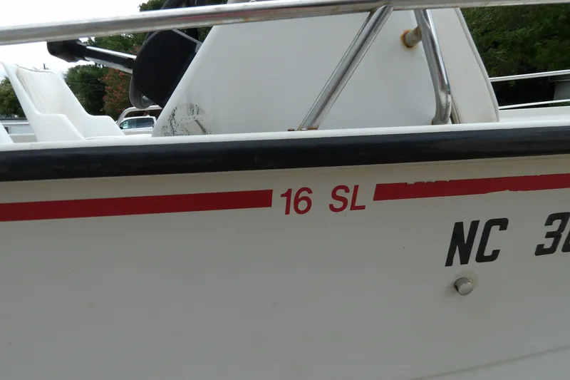 Slide: The Image of 1991 Boston Whaler SL16 boat with red stripe and registration number NC 36. - 18