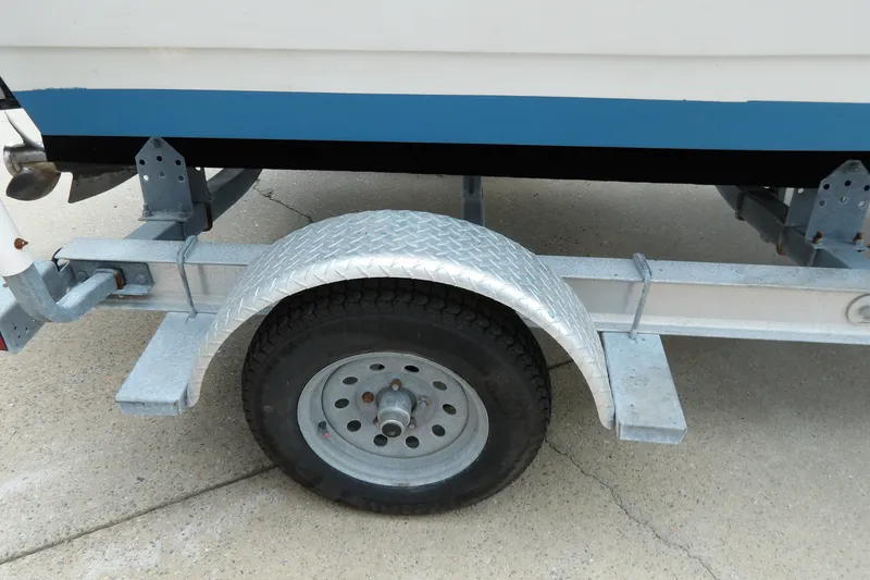 Slide: The Image of Trailer wheel of a 1991 Boston Whaler SL16 boat on concrete surface. - 17