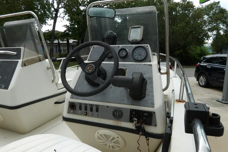 Slide: The Image of 1991 Boston Whaler SL16 boat dashboard with steering wheel and gauges. - 15