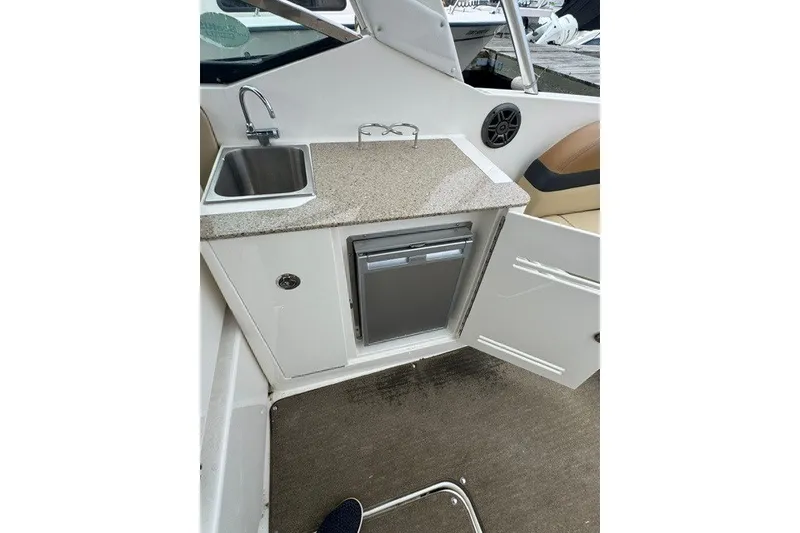 Slide: The Image of 2016 Sea Ray 300 SLX boat interior with sink, countertop, and mini fridge. - 13