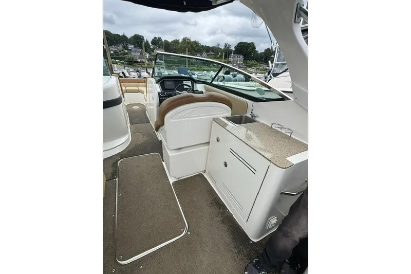 Slide: The Image of 2016 Sea Ray 300 SLX boat interior with helm, seating, and kitchenette. - 10