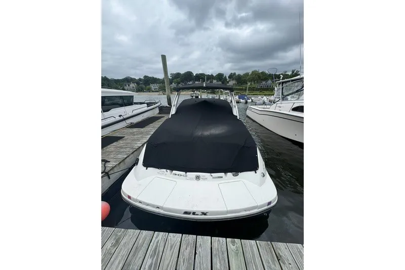 Slide: The Image of 2016 Sea Ray 300 SLX boat docked with cover, overcast sky. - 8