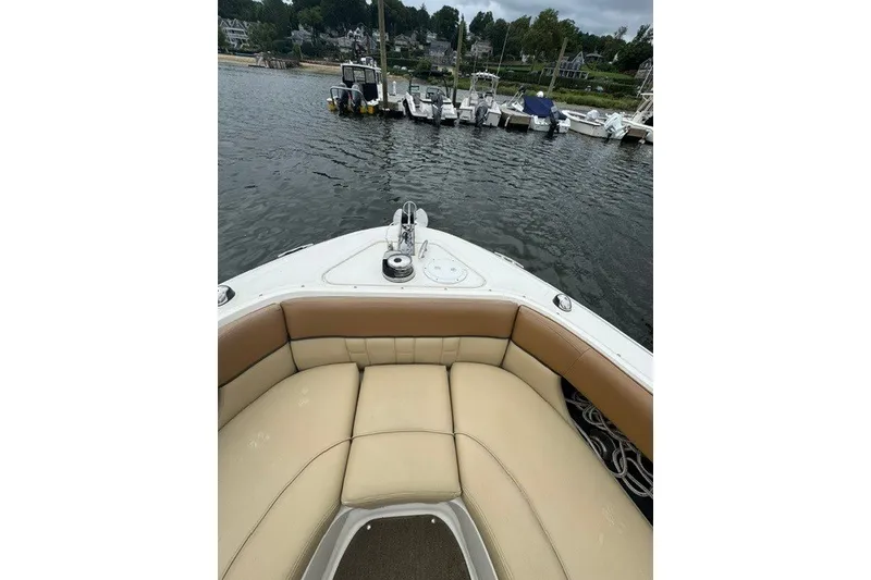 Slide: The Image of 2016 Sea Ray 300 SLX boat interior with tan seating, docked at a marina. - 27