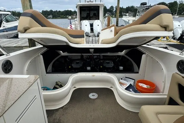 Slide: The Image of 2016 Sea Ray 300 SLX boat interior with open engine compartment at dock. - 22