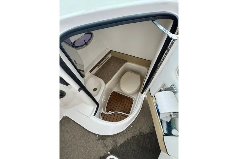 Slide: The Image of 2016 Sea Ray 300 SLX boat bathroom with toilet, sink, and wooden floor mat. - 19