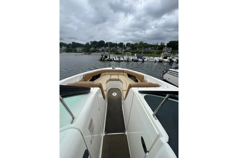 Slide: The Image of 2016 Sea Ray 300 SLX boat with tan seating, docked at a marina under cloudy skies. - 28