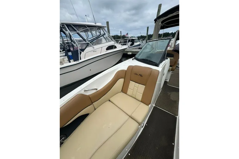 Slide: The Image of 2016 Sea Ray 300 SLX boat with tan seating at a marina. - 26