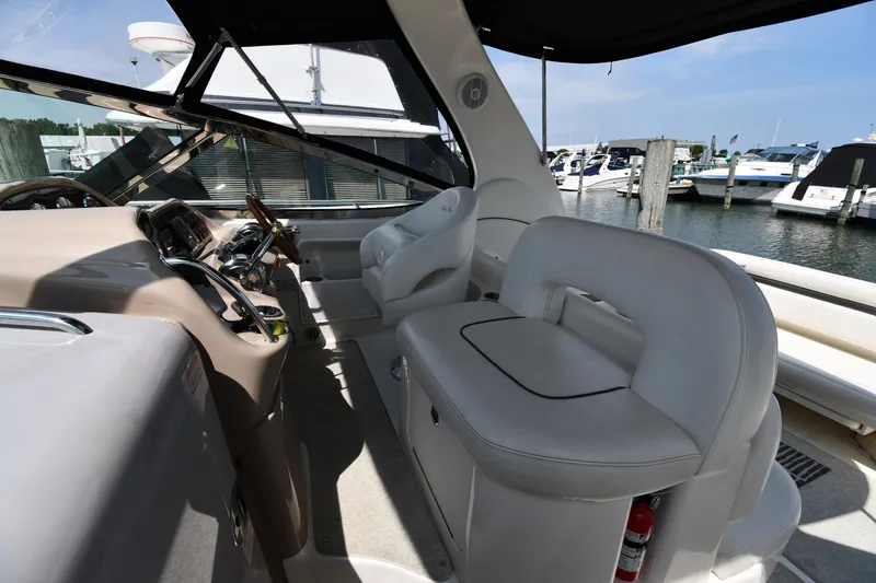 Slide: The Image of 2004 Sea Ray 360 Sundancer cockpit with plush seating and marina view. - 18