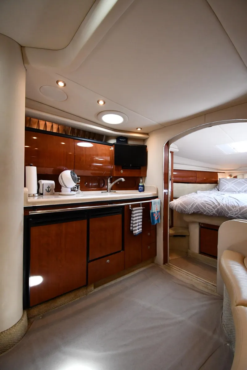 Slide: The Image of Interior of 2004 Sea Ray 360 Sundancer yacht, featuring a modern kitchen and cozy bedroom. - 41