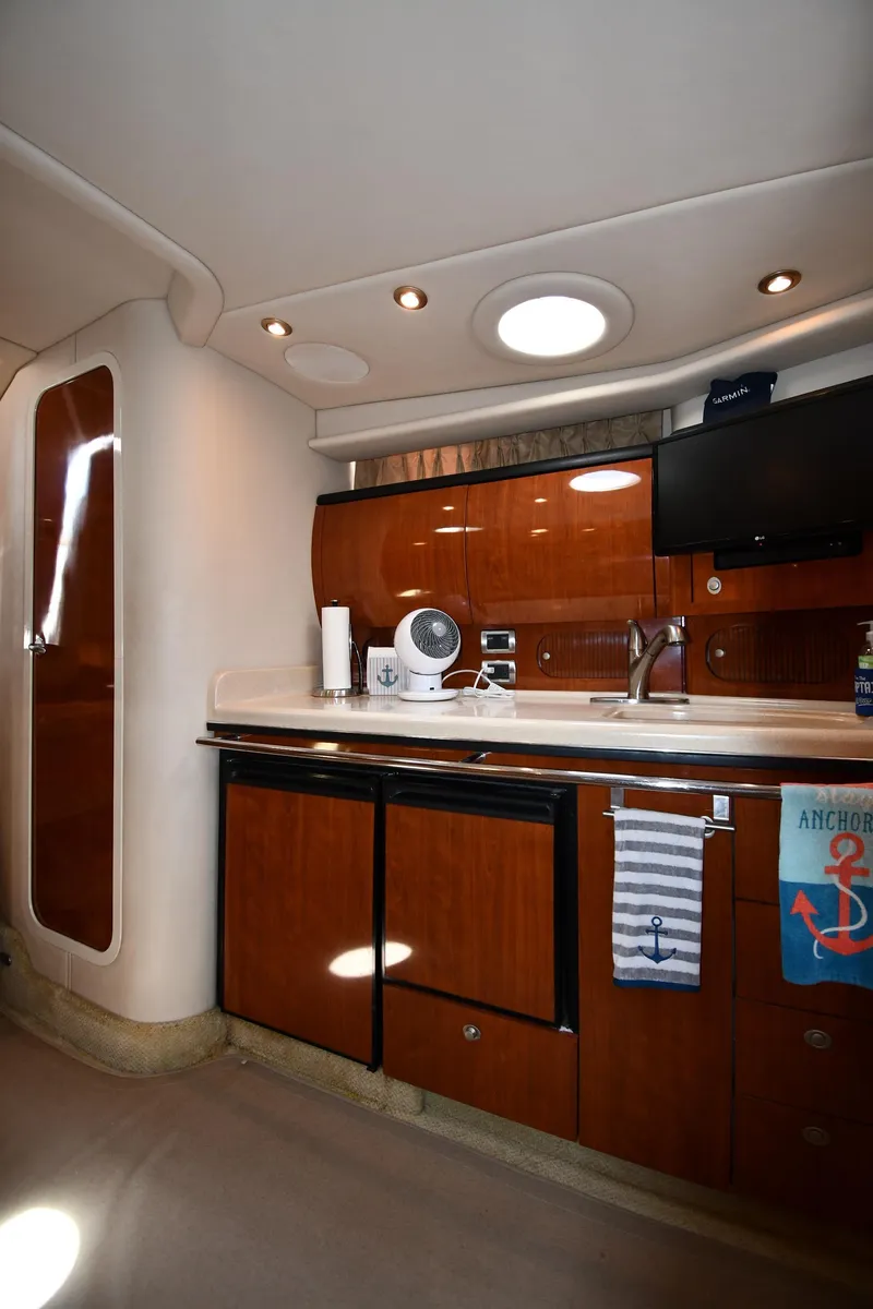 Slide: The Image of 2004 Sea Ray 360 Sundancer interior kitchen with wood cabinetry and modern appliances. - 43