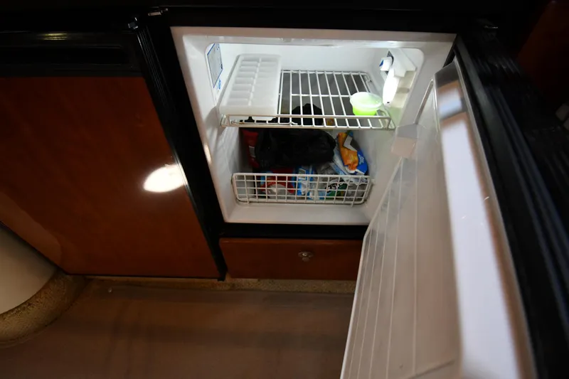 Slide: The Image of An open refrigerator in a 2004 Sea Ray 360 Sundancer shows frozen food items. - 50