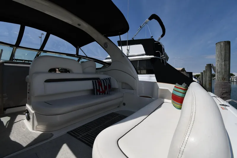 Slide: The Image of 2004 Sea Ray 360 Sundancer boat interior with white seating and colorful cushions. - 20