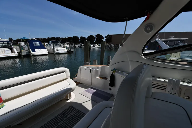 Slide: The Image of 2004 Sea Ray 360 Sundancer interior at marina, showcasing seating and docked boats. - 28
