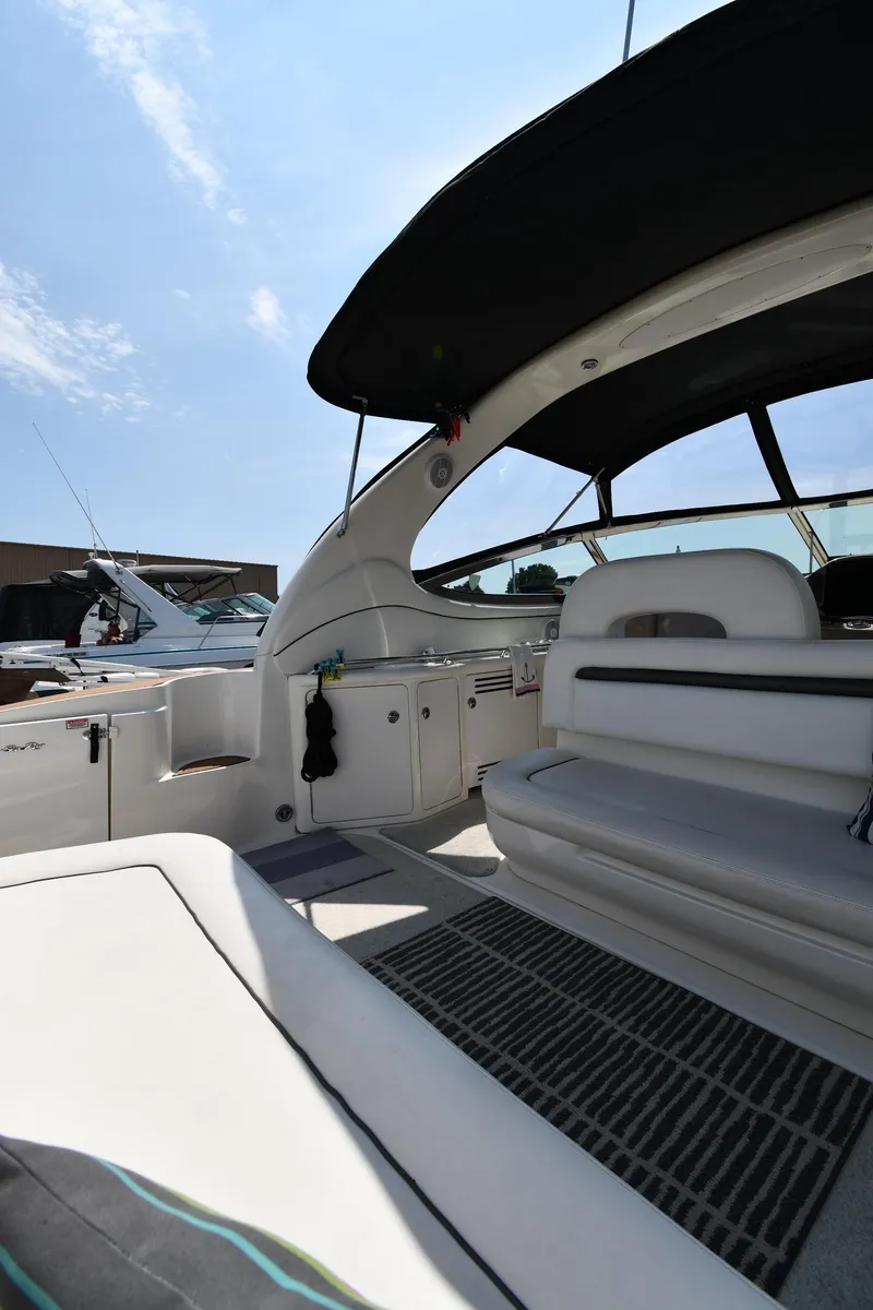 Slide: The Image of 2004 Sea Ray 360 Sundancer interior with seating, under a sunny sky. - 23