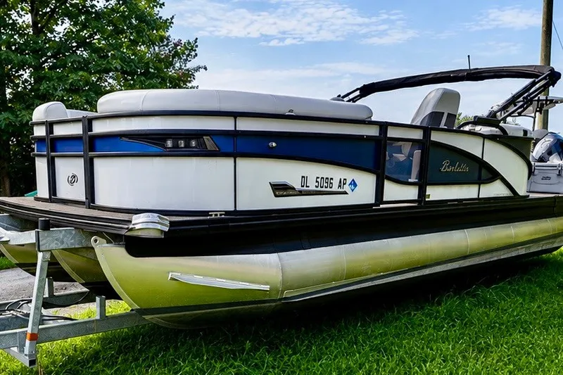 Slide: The Image of 2023 Barletta Corsa 21Q pontoon boat on trailer, parked on grass. - 9