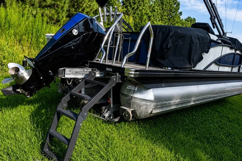 Slide: The Image of 2023 Barletta Corsa 21Q pontoon boat with outboard motor and boarding ladder on grass. - 13