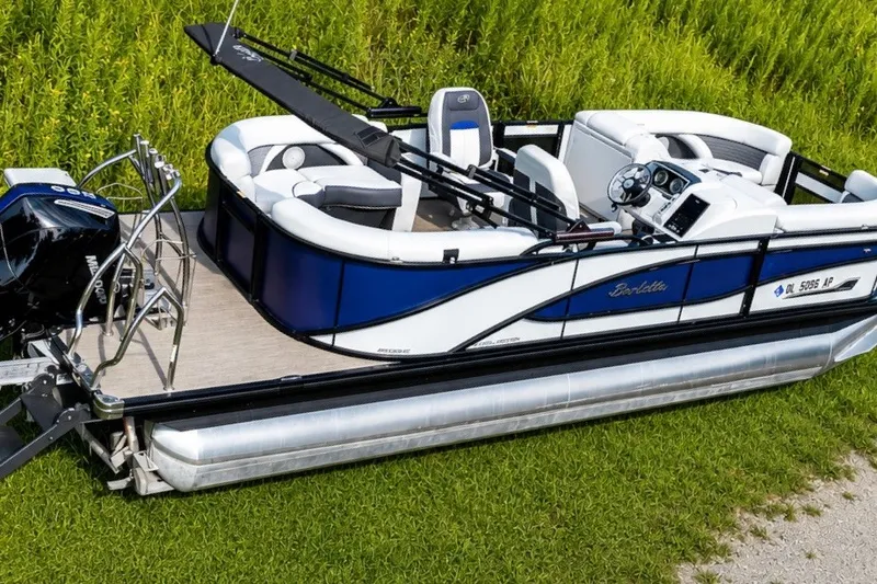 Slide: The Image of 2023 Barletta Corsa 21Q pontoon boat with sleek design, parked on grass. - 1