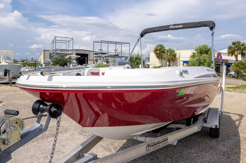 Slide: The Image of 2021 Hurricane SunDeck Sport 185 OB boat on trailer, red and white design, outdoor display. - 13