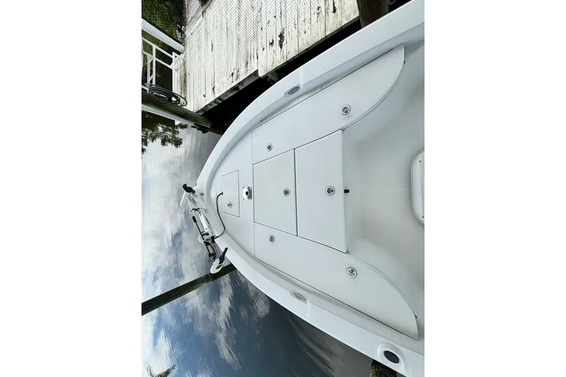 Slide: The Image of 2002 Ranger 2300 Bay Ranger boat docked, showcasing spacious deck and storage compartments. - 16