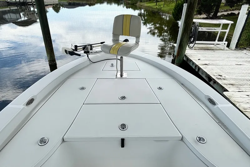 Slide: The Image of 2002 Ranger 2300 Bay Ranger boat with seating, docked by calm water. - 17