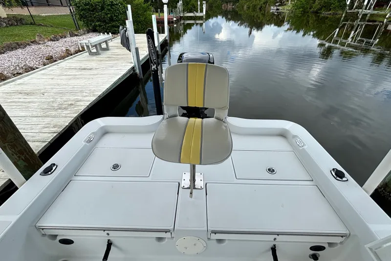 Slide: The Image of 2002 Ranger 2300 Bay Ranger boat with seating, docked by calm waters. - 21