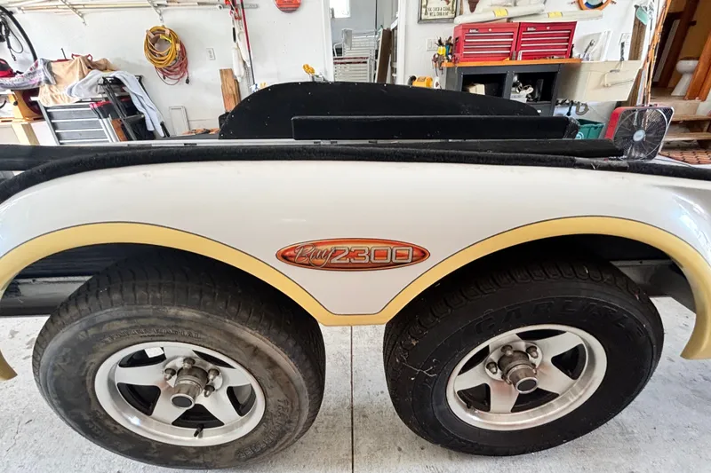 Slide: The Image of 2002 Ranger 2300 Bay Ranger trailer with dual wheels in a garage setting. - 25
