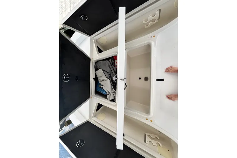 Slide: The Image of 2002 Ranger 2300 Bay Ranger boat storage compartments with open hatches and visible gear. - 15