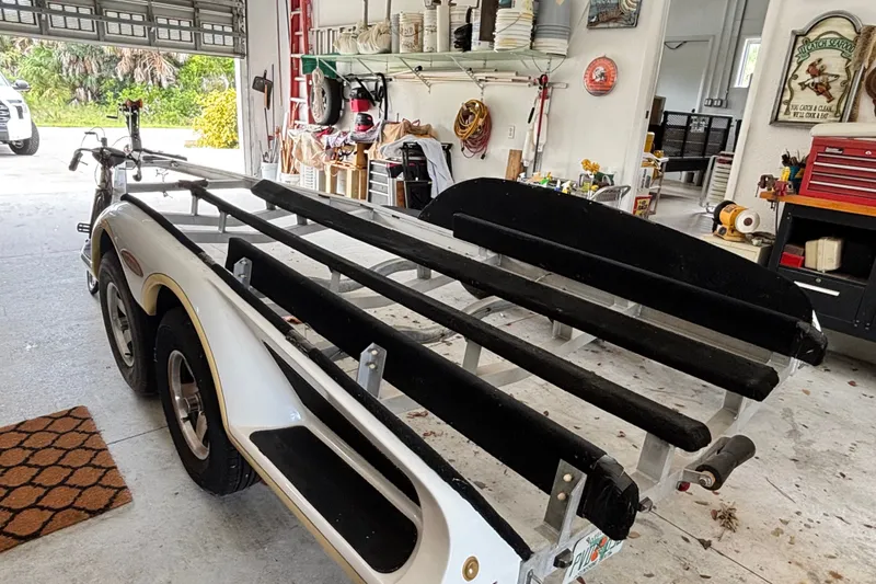 Slide: The Image of 2002 Ranger 2300 Bay Ranger boat trailer in a garage with tools and equipment. - 24